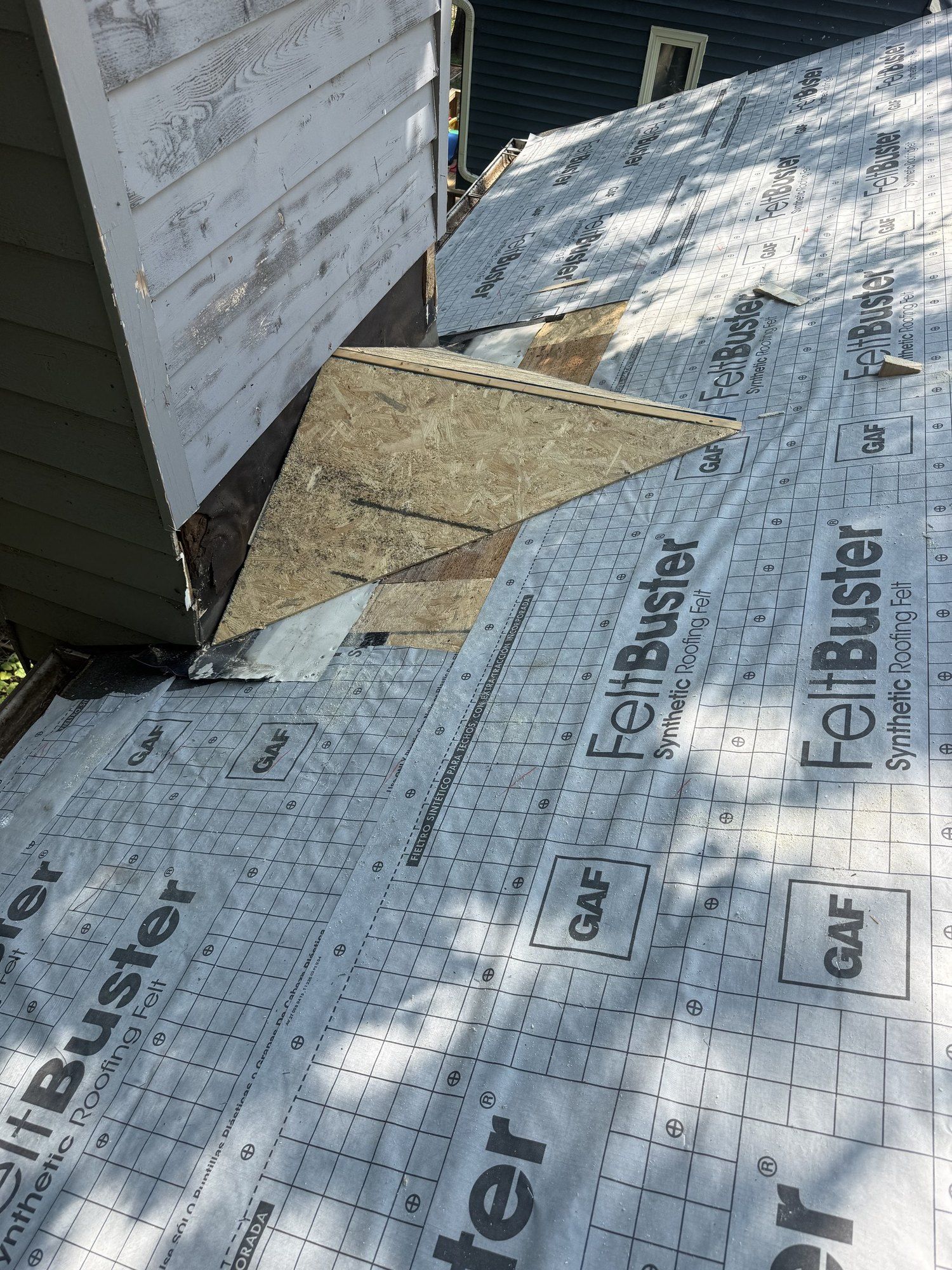 GAF FeltBuster synthetic underlayment rolled out across a roof deck