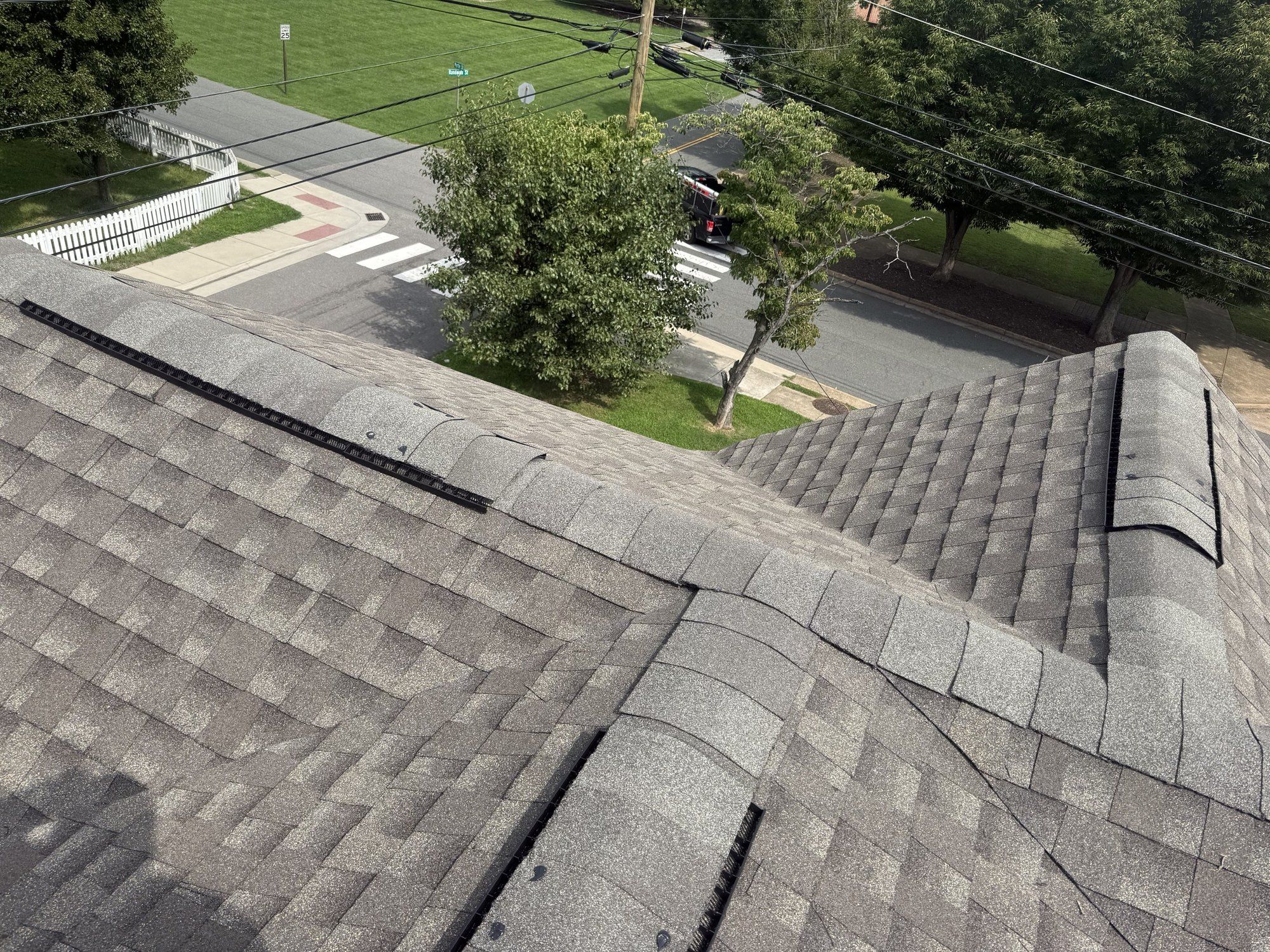 Close view of new hip and ridge caps meeting on a gray architectural shingle roof